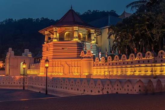 Golden spires of the Temple of the Tooth Relic against blue sky